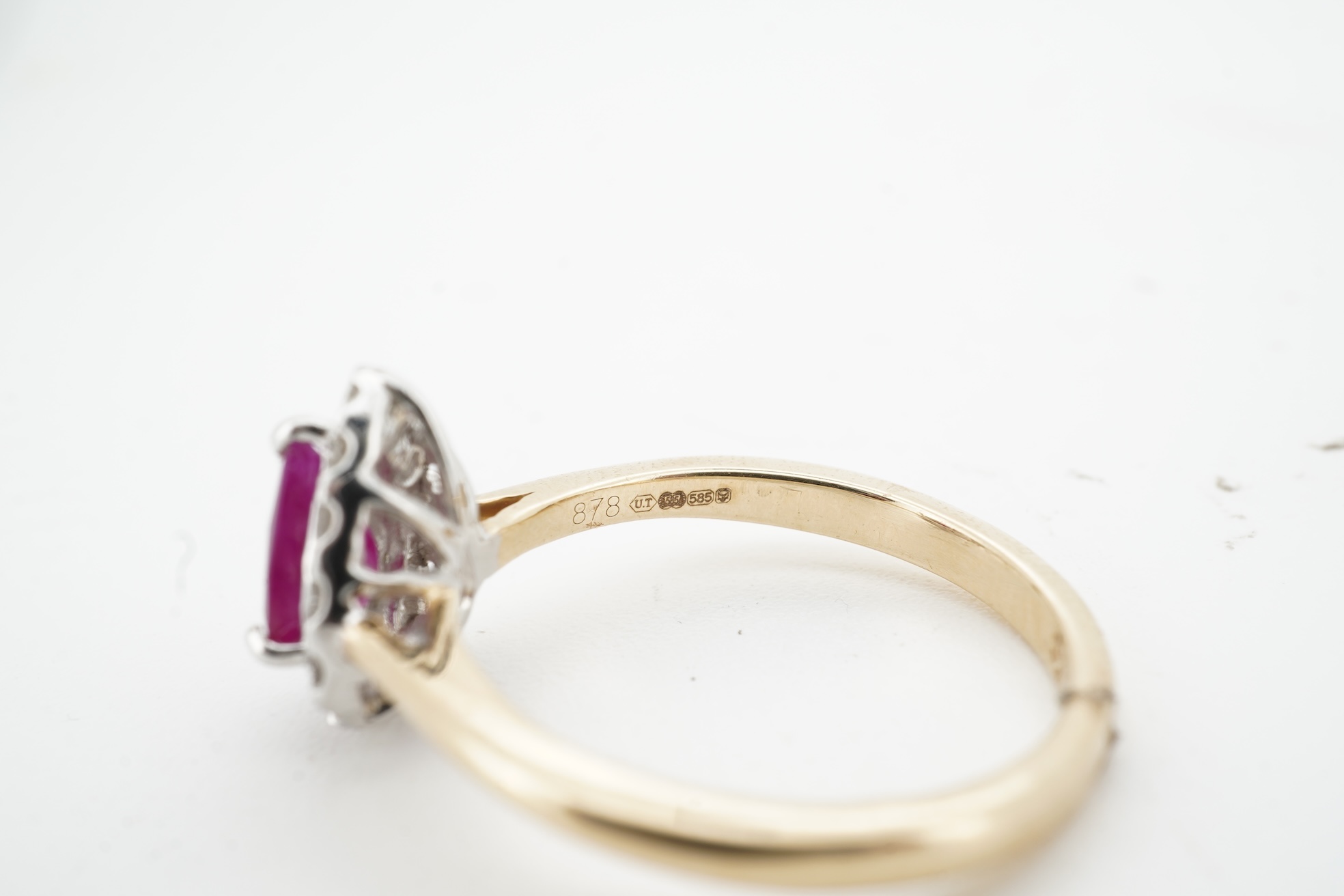 A ruby and diamond cluster ring, claw-set with a pear-shaped ruby weighing approximately 0.60 carats, within a border of brilliant-cut diamonds totalling approximately 0.42 carats, mounted in 14ct gold, size N, British h